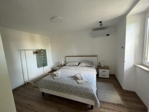een slaapkamer met een bed met 2 kussens erop bij Apartment Hermes in Lovran