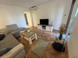 un salon avec un canapé et une table dans l'établissement Apartment Hermes, à Lovran