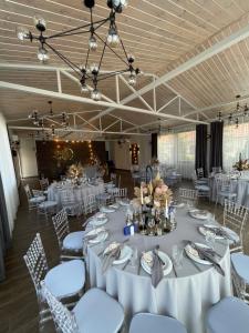 une grande salle de banquet avec des tables et des chaises blanches dans l'établissement Veles Hotel, à Fontanka