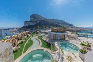 a resort with a pool with a mountain in the background at Ocean Spa Plaza Studio Apartment in Gibraltar