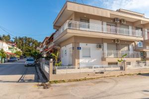 ein Gebäude mit einem davor geparkten Auto in der Unterkunft DEL MAR APARTMENTS I in Agía Triás