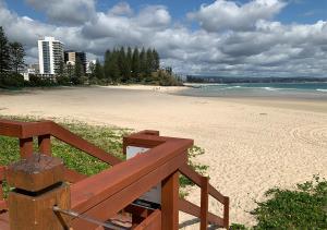 a view of a beach with a wooden bench at Cooly Coastal Escape walk to beach & shops in Gold Coast