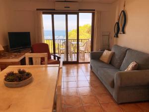 een woonkamer met een bank en een tafel bij Apartamento con espectaculares vistas al Mediterráneo in Calella de Palafrugell