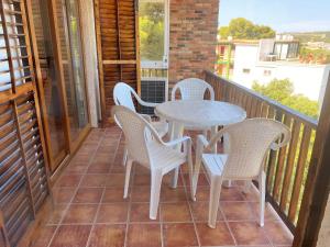 een patio met een tafel en stoelen op een balkon bij Apartamento con espectaculares vistas al Mediterráneo in Calella de Palafrugell