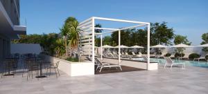 un patio con sedie, tavoli e una piscina di B21 Lifestyle Hotel a Bari