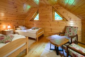 a bedroom with two beds in a log cabin at Świt w Gorcach - dom wakacyjny in Ochotnica Dolna