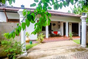 a house with white columns and a patio at Ranjith Guest in Mirissa