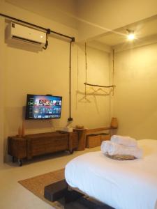 a bedroom with a bed and a flat screen tv at Makai NAP in Ban Lam Pi