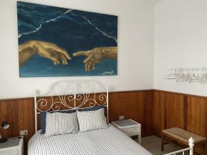 una camera da letto con un letto e un dipinto sul muro di Las 3 Palmeras de Arrecife ad Arrecife