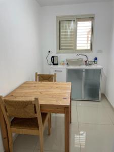 a kitchen with a wooden table and a sink at פרטיות וחוויה אצל יעקב וירדנה Privacy and an experience at Jacob and Yardena in Afula