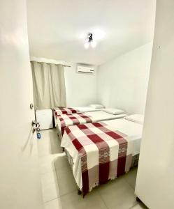 a bedroom with two beds and a door open at Hotel Casa Blanca in Campina Grande