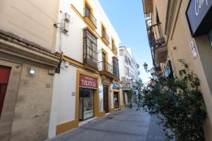 una calle vacía en un callejón entre edificios en Apartamentos Santa María 15, en Jerez de la Frontera