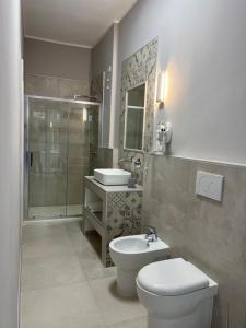 uma casa de banho com um WC, um lavatório e um chuveiro em Stanze d’Autore em Taranto
