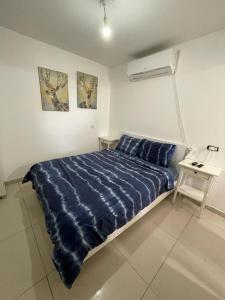 a bedroom with a blue comforter on a bed at פרטיות וחוויה אצל יעקב וירדנה Privacy and an experience at Jacob and Yardena in Afula