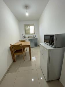 a kitchen with a table and a microwave at פרטיות וחוויה אצל יעקב וירדנה Privacy and an experience at Jacob and Yardena in Afula