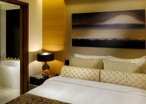 Westminster Dubai Mall في دبي: غرفة نوم بسرير ودهان على الحائط