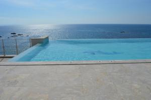 una piscina con vista sull'oceano di Beach Villa Pantheon a Pomos
