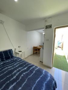 a bedroom with a blue bed and a window at פרטיות וחוויה אצל יעקב וירדנה Privacy and an experience at Jacob and Yardena in Afula
