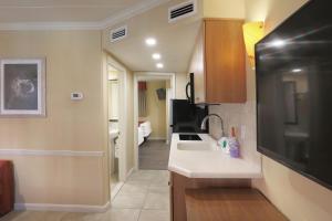 a small kitchen with a sink and a microwave at Fleur de Lis Beach Motel in Wildwood Crest