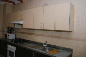 a kitchen with a sink and white cabinets at MOHAMMEDIA 66 in Mohammedia