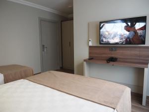 um quarto com uma cama e uma televisão na parede em ZENİA OTEL em Antalya