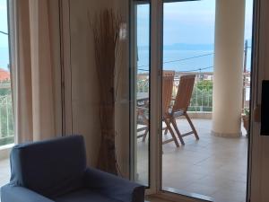 a living room with a chair and a sliding glass door at Χαλκιδική Κρυοπηγή in Kriopigi