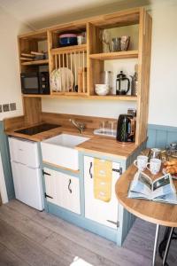 a kitchen with a sink and a table at Close to Nature Easy to Find shepherd's hut in North Molton