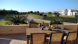 a wooden table with wine glasses on a patio at Kos Villa - Family Comfort with large Garden, Jacuzzi in Kos