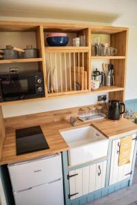 a kitchen with a sink and a microwave at Close to Nature Easy to Find shepherd's hut in North Molton