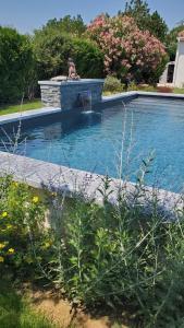 a woman is sitting in a swimming pool at L’oliveraie in Robion en Luberon