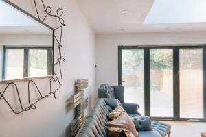 uma sala de estar com duas cadeiras azuis e um espelho em Lush & Spacious 3BD House - East Brighton em Brighton & Hove