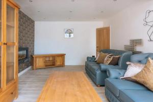 a living room with a blue couch and a fireplace at Lush & Spacious 3BD House - East Brighton in Brighton & Hove