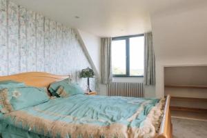 um quarto com uma cama grande e lençóis azuis em Lush & Spacious 3BD House - East Brighton em Brighton & Hove