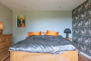 um quarto com uma cama com uma parede azul em Lush & Spacious 3BD House - East Brighton em Brighton & Hove
