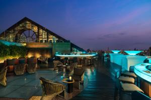 a rooftop bar with tables and chairs at night at lebua at State Tower in Bangkok
