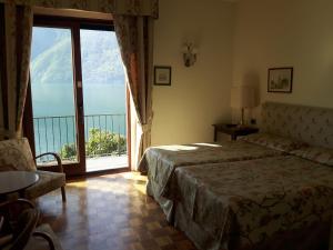 ein Schlafzimmer mit einem Bett und einem großen Fenster in der Unterkunft Hotel Stella D'Italia in Valsolda