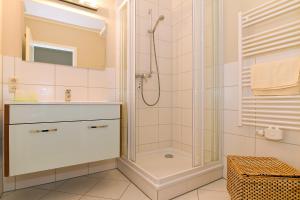 La salle de bains est pourvue d'une douche et d'un lavabo. dans l'établissement Urlaubsräume am Meer Urlaubsräume am Meer 3-2, à Fulgen