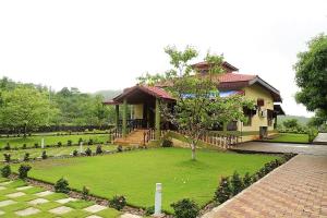 a house with a green lawn in front of it at Wandr Zen in Khopoli