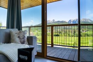 Cette chambre dispose d'un canapé et d'un balcon avec vue. dans l'établissement Apartament Owca na wypasie by Apart Concept Podhale, à Kościelisko