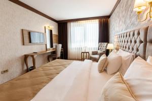 イスタンブールにあるマーブル ホテルの大きなベッドとデスクが備わるホテルルームです。