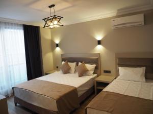 um quarto de hotel com duas camas e um lustre em ZENİA OTEL em Antalya
