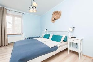 a blue bedroom with a bed and a window at Jaśmin in Rowy
