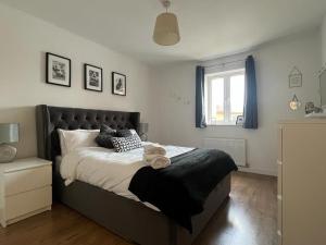 sypialnia z dużym łóżkiem i oknem w obiekcie Home Away from Home: Cozy Two Bedroom Apartment w mieście Banbury