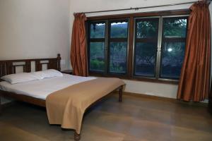 a bedroom with a bed and a large window at Wandr Zen in Khopoli