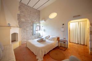 um quarto com uma cama branca e uma parede de pedra em Lama Di Luna Biomasseria em Montegrosso