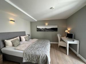 a bedroom with a bed and a desk with a computer at Hüs am Seedeich in Westerland (Sylt)