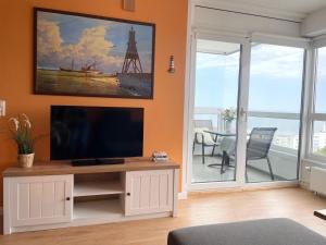 a living room with a flat screen tv on a cabinet at Frische Brise FeWo12 09 in Cuxhaven