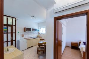 una cucina con porta che conduce a una sala da pranzo di Apartments Luci a Rab