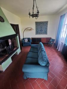 sala de estar con sofá azul y chimenea en Villetta Il Nespolo, en Barberino di Mugello