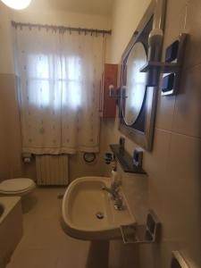 a bathroom with a sink and a toilet and a mirror at Villetta Il Nespolo in Barberino di Mugello